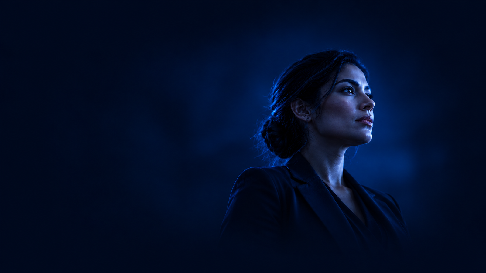 Latin American professional illuminated in blue against a deep navy background.